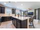 Modern kitchen with island, stainless steel appliances, and dark cabinetry at 406 Misterioso St, Henderson, NV 89011