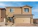 Two-story house with tan exterior, two-car garage, and landscaped front yard at 4253 Gold Desert St, North Las Vegas, NV 89032