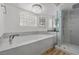 Bathroom with a large soaking tub, glass-enclosed shower, and hardwood floors at 43 Innisbrook Ave, Las Vegas, NV 89113