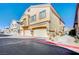 Exterior view of a modern townhouse with a two-car garage and well-maintained landscaping at 4710 Frasers Owl Ave # 103, North Las Vegas, NV 89084