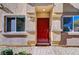 Red front door entry to a townhome with landscaping at 4710 Frasers Owl Ave # 103, North Las Vegas, NV 89084