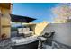 Relaxing patio area with comfortable seating, an umbrella, and a textured privacy wall at 4710 Frasers Owl Ave # 103, North Las Vegas, NV 89084