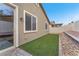 Side yard features artificial grass, rock landscaping, and a white fence at 5640 Akula Bay St, North Las Vegas, NV 89081