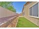 Side yard featuring a decorative rock garden and synthetic grass at 5640 Akula Bay St, North Las Vegas, NV 89081