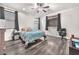 Main bedroom featuring wood-look floors, ceiling fan and multiple windows for natural light at 5640 Akula Bay St, North Las Vegas, NV 89081