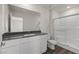 Bathroom with a shower, toilet, and modern vanity with dark countertop at 6240 Blood Lily Ave, Las Vegas, NV 89122