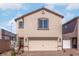 Two-story house with beige siding, a two-car garage, and landscaping at 6240 Blood Lily Ave, Las Vegas, NV 89122