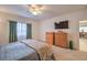 Bright bedroom featuring a comfortable bed, natural light, and ample storage with wooden dresser and wall mounted TV at 6733 Violet Bluff Ct, North Las Vegas, NV 89084