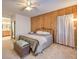 Cozy bedroom with wood paneling, plush carpet, a comfortable bed, and stylish decor with decorative storage chest at 6733 Violet Bluff Ct, North Las Vegas, NV 89084