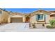 Tan house with teal shutters, two-car garage, and landscaped yard at 6733 Violet Bluff Ct, North Las Vegas, NV 89084