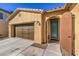 Inviting front entrance features an arched wrought iron door, two-car garage, and manicured landscaping at 6733 Violet Bluff Ct, North Las Vegas, NV 89084