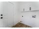 Clean laundry room with white cabinets and wood floors at 6808 Rose Petal Ave, Las Vegas, NV 89130