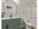 Modern bathroom with green vanity, white toilet and bathtub at 7131 Rosecrans St, Las Vegas, NV 89166