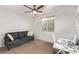 Bright bedroom with a couch, desk, and ceiling fan at 7131 Rosecrans St, Las Vegas, NV 89166