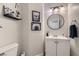 Stylish powder room with a white vanity, geometric wallpaper, and circular mirror at 7337 Savannah Falls St, Las Vegas, NV 89131