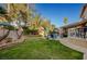 Spacious backyard oasis with a sparkling pool, lush grass, and patio area at 7420 Bush Garden Ave, Las Vegas, NV 89129