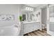 Elegant bathroom with double vanity, soaking tub, and barn door at 7420 Bush Garden Ave, Las Vegas, NV 89129