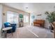 Bright living room with a piano, comfortable armchair, and large windows at 848 Waterloo Dr, Henderson, NV 89002