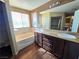 Bathroom with double vanity, soaking tub, and wood-look floors at 865 Gleamstar Ave, Las Vegas, NV 89123