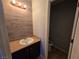 Updated half bathroom with modern vanity and wood-look tile at 865 Gleamstar Ave, Las Vegas, NV 89123