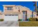 Two-story house with beige exterior, white garage door, and landscaped lawn at 8986 Lillyhammer Ct, Las Vegas, NV 89147