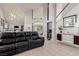 Relaxing living room with leather sectional sofa, high ceilings and staircase at 8986 Lillyhammer Ct, Las Vegas, NV 89147