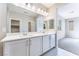 Well-lit bathroom boasting a double vanity with white countertops and a large mirror at 9247 Lunar Phase St, Las Vegas, NV 89143