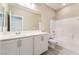 Bathroom features a double sink vanity, toilet, and shower-tub combination with bright white tile and neutral wall paint at 9247 Lunar Phase St, Las Vegas, NV 89143