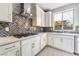 Stylish kitchen featuring white cabinets, a modern range hood, and a herringbone tile backsplash at 9247 Lunar Phase St, Las Vegas, NV 89143