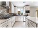 Bright kitchen with white cabinets, countertops, stainless appliances, and a view of a new home under construction at 9247 Lunar Phase St, Las Vegas, NV 89143