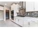 Well-lit kitchen featuring stainless steel appliances, sleek white cabinets, and herringbone tile backsplash at 9247 Lunar Phase St, Las Vegas, NV 89143