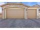 Three-car garage with stone exterior and neutral-colored doors at 3957 Little Creek Ave, Las Vegas, NV 89141