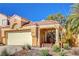 Tan two-story house with tile roof, attached garage, and landscaped yard at 1809 Derbyshire Dr, Las Vegas, NV 89117