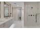 Bright bathroom featuring a long double sink vanity with white marble floors and a glass enclosed shower at 3104 Conners Dr, Las Vegas, NV 89107