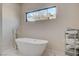 Bright bathroom features a modern tub under window providing natural light and a rack of neatly folded towels at 3104 Conners Dr, Las Vegas, NV 89107