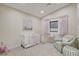 Charming Bedroom with a white crib, cozy chair, and soft pink accents at 3104 Conners Dr, Las Vegas, NV 89107