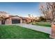 Picture of a brick single story house with a well manicured lawn, long driveway and mature trees at 3104 Conners Dr, Las Vegas, NV 89107