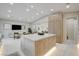 Open-concept kitchen with custom wood cabinets, marble island, and open to dining area with modern finishes at 3104 Conners Dr, Las Vegas, NV 89107