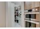 Pantry features custom shelving and cabinets, providing organized storage space with built-in oven and microwave at 3104 Conners Dr, Las Vegas, NV 89107