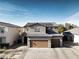 Two-story house with brown garage door and solar panels on the roof at 3439 Midnight Shadows Way, North Las Vegas, NV 89032