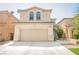 Two story house with beige exterior, two car garage, and landscaped yard at 4937 Caprock Canyon Ave, Las Vegas, NV 89139