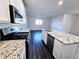 Open kitchen with granite countertops, stainless steel appliances, white cabinets, and wood flooring at 846 Star Estates Ave, North Las Vegas, NV 89086