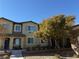 Two story house with gray shutters and a tree in front at 8520 Insignia Ave # 104, Las Vegas, NV 89178