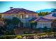 Luxury two-story home with a terracotta tile roof, fountain, and mountain views at 9513 Verlaine Ct, Las Vegas, NV 89145