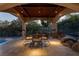 Covered patio with seating area, adjacent to pool and landscaping at 9513 Verlaine Ct, Las Vegas, NV 89145