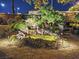 Night view of a relaxing backyard with a pond and waterfall feature, illuminated with landscape lighting at 10372 Hawks Wing St, Las Vegas, NV 89178