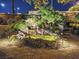 Night view of a backyard with a pond, waterfall, and seating area at 10372 Hawks Wing St, Las Vegas, NV 89178