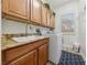 Laundry room with washer, dryer, cabinets, and granite countertop at 10372 Hawks Wing St, Las Vegas, NV 89178