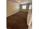 Simple carpeted bedroom with window and neutral walls at 121 E Cypress Dr, Henderson, NV 89015