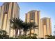 Luxury high-rise building with modern architecture and palm trees at 135 E Harmon Ave # 1007, Las Vegas, NV 89109